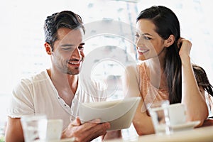 Happy couple, coffee and relaxing in cafe with tablet, smile and together for romance. Cheerful relationship, man and