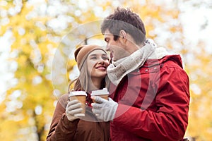 Happy couple with coffee walking in autumn park