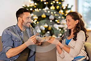 happy couple with cookies on christmas at home