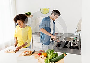 Happy couple cooking food at home kitchen