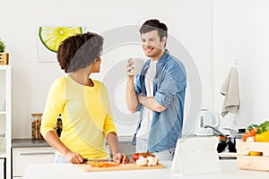 Happy couple cooking food at home kitchen