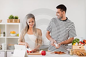 Happy couple cooking food at home kitchen