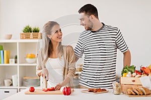 Happy couple cooking food at home kitchen