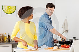 Happy couple cooking food at home kitchen