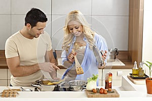 Happy couple cooking in kitchen