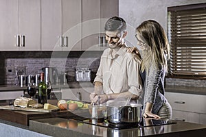 Happy couple cooking a meal in the kitchen flirting bonding