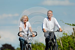 Happy couple cycling outdoors in summer