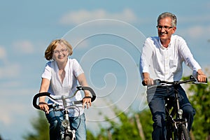 Happy couple cycling outdoors in summer