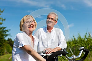 Happy couple cycling outdoors in summer