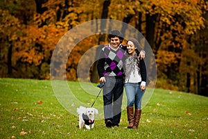 Happy Couple with Dog During Autumn