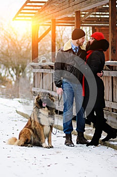 Happy couple with dogs in winter forest. Lovely moments outdoor