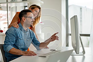 Happy couple doing business together working at small office