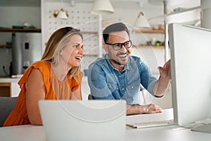 Happy couple doing business together working at small office