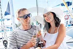 Happy couple drinking champagne on a boat