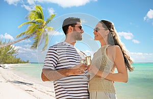 happy couple drinking champagne on tropical beach