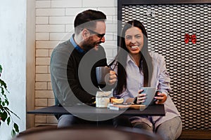 Happy couple drinking coffee in cafe.