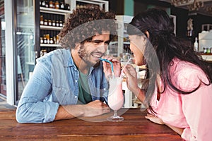 Happy couple drinking milkshake