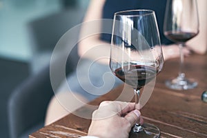 Happy couple drinking red wine. Selective focus on wine glass