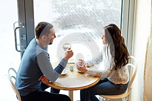 Happy couple drinking tea and coffee at cafe