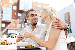 Happy couple drinking wine at open-air restaurant