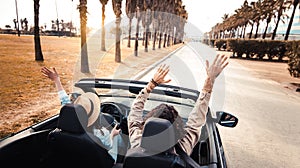 Happy couple driving convertible car enjoying summer vacation