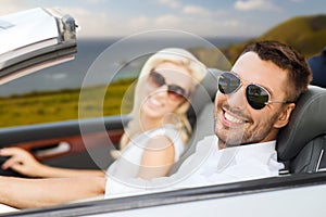 Happy couple driving in convertible car