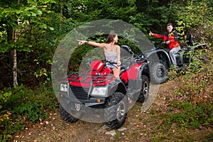 Happy couple driving four-wheelers ATV