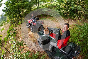 Happy couple driving four-wheelers ATV