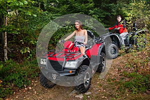 Happy couple driving four-wheelers ATV