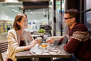 Happy couple eating cake for dessert at cafe