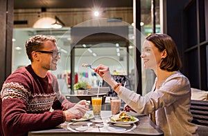 Happy couple eating dinner at vegan restaurant