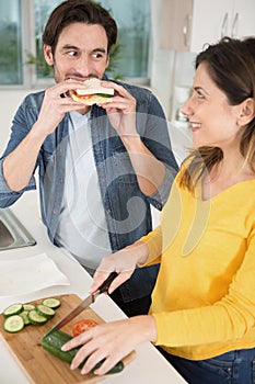 happy couple eating vegetable salad and sandwhich