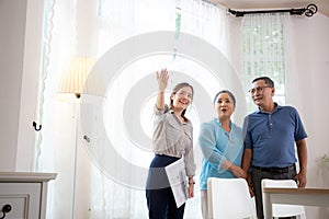 Happy couple elderly looking new home while agent real estate explaining and visit.