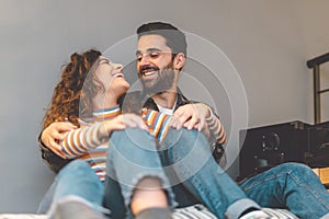 Happy couple embracing in living room at home - Young lovers sharing tender moments together