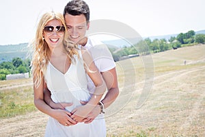 Happy couple embracing outdoors on sunny day