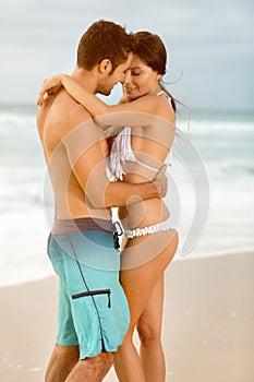 Happy couple embracing over sunset beach