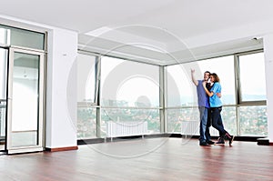 Happy couple in empty apartment