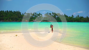 Happy couple enjoy honeymoon on the tropical beach at sunny summer day