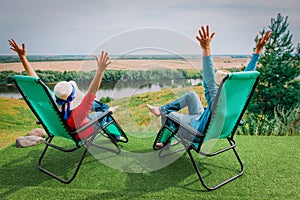 Happy couple enjoy nature, family hands up while relax in the country