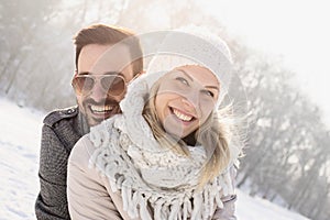 Happy couple enjoying the beautiful snow captured on a cold and snowy day