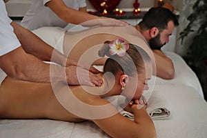 Happy couple enjoying a day at spa while having back massage