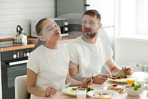 Happy couple enjoying delicious breakfast at home