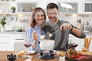 Happy couple enjoying fondue dinner photo