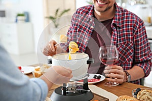 Happy couple enjoying fondue dinner at home photo