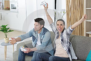happy couple enjoying leisure time by playing video games together