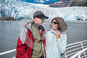 Happy couple enjoys her boat tour to the glacier in Alaska, USA.