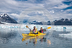Happy couple enjoys ocean kayaking bear glacier during their vacation trip to in Alaska, USA. photo