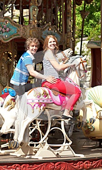 Happy couple enjyong the ride on merry-go-round