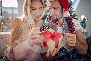 Happy couple exchanging Christmas gifts