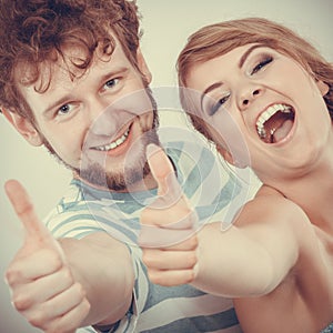 Happy couple excited smiling holding thumb up gesture,